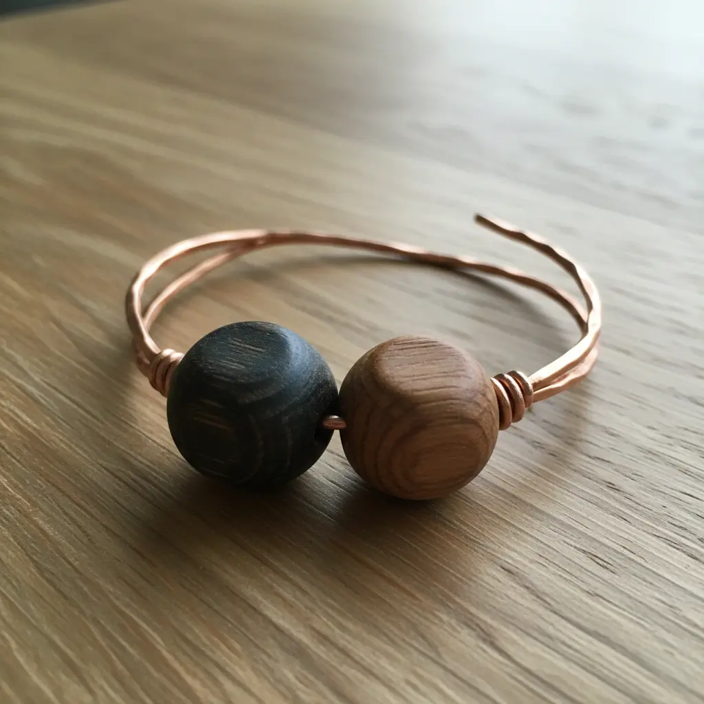 A warm copper wire bangle holding three large, natural wooden beads with visible grain.