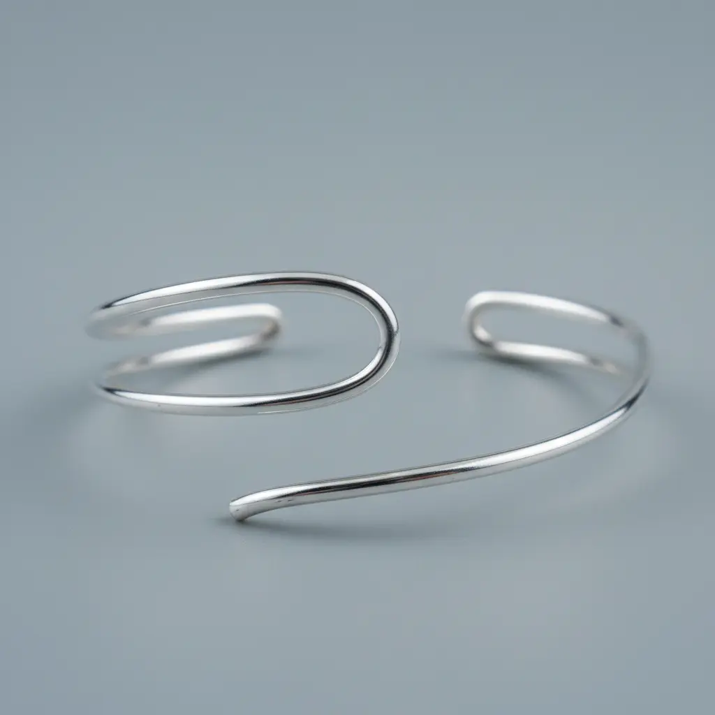 A delicate silver plated wire cuff bracelet formed from two overlapping curved wires with a bright polished finish.