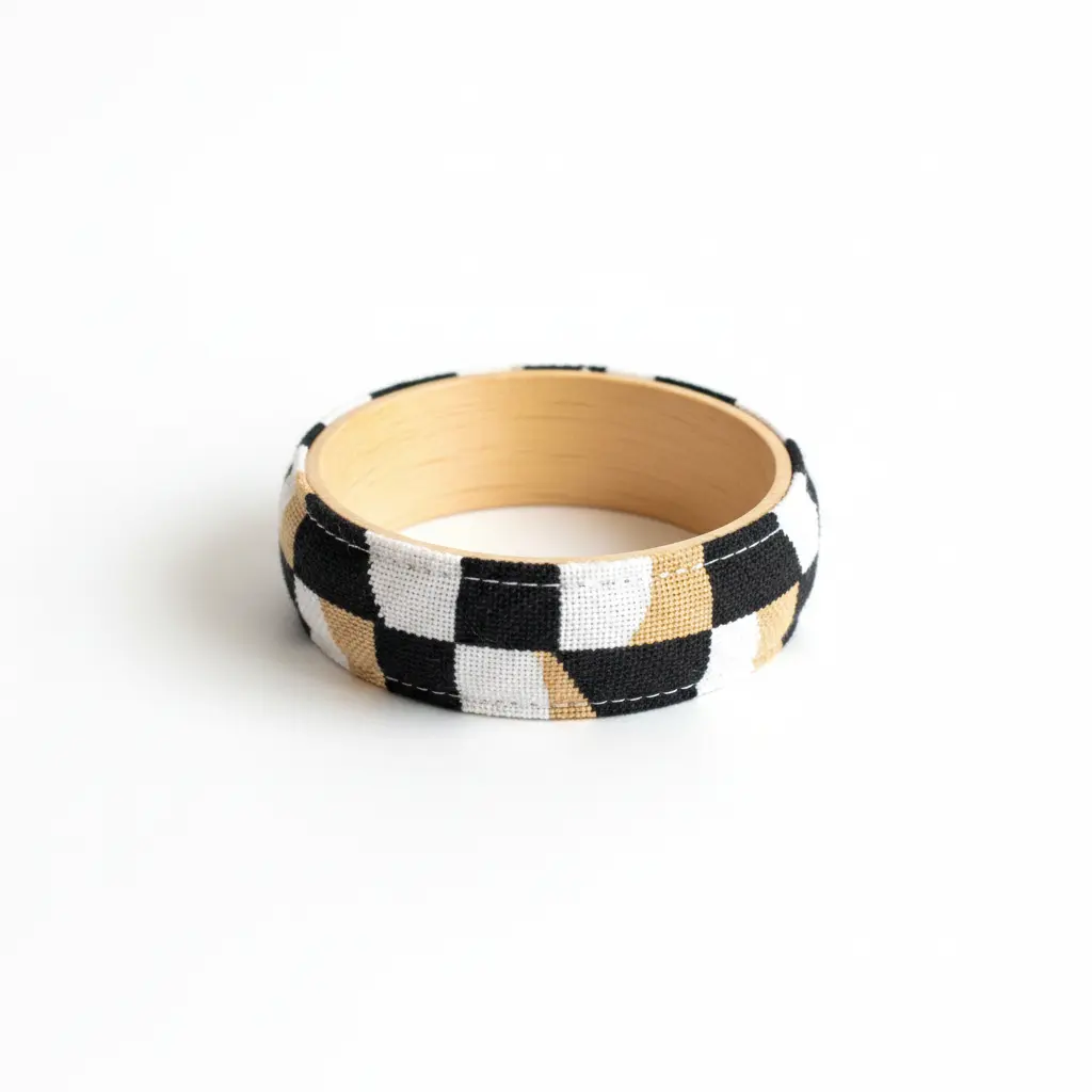 A geometric print fabric strip wrapped around a plain wooden bangle, with a clean, modern finish.