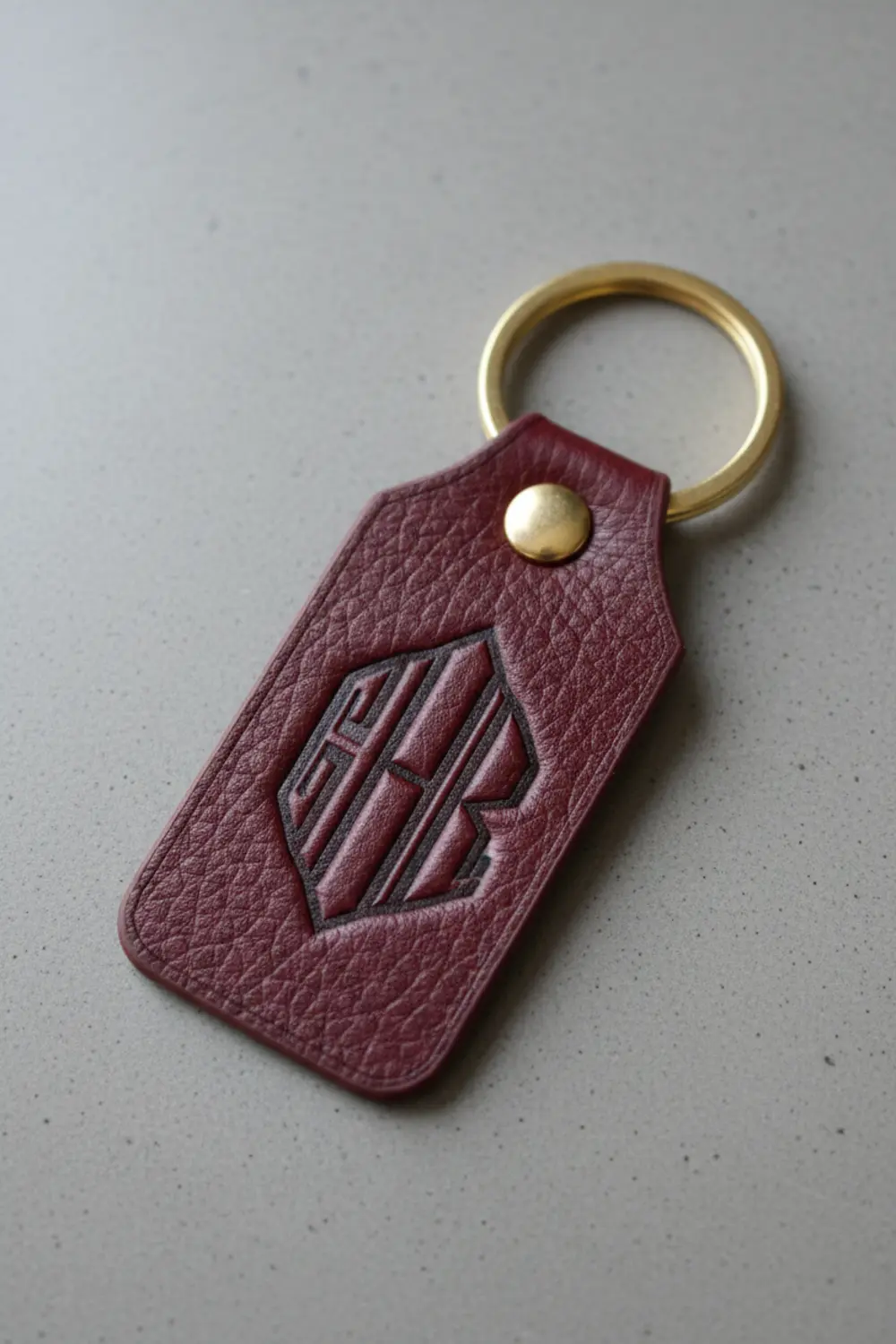 A circular faux leather keychain in navy blue with a crisp, white letter 'A' applied using heat transfer vinyl.