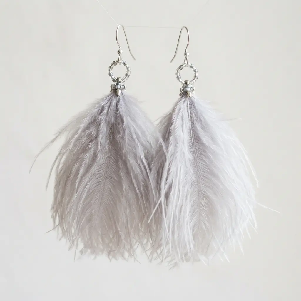 A cluster of delicate, pale gray ostrich feathers forming a soft, elegant earring drop.