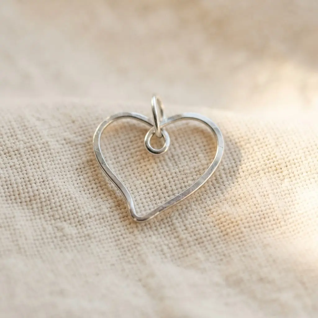 A simple, elegant necklace featuring a minimalist heart shape formed from a single, continuous loop of thin silver wire.