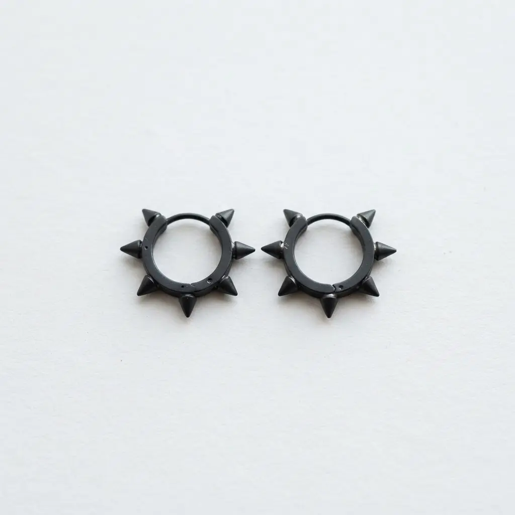 A pair of silver hoop earrings with several small, matte black cone spikes attached along the outer edge.