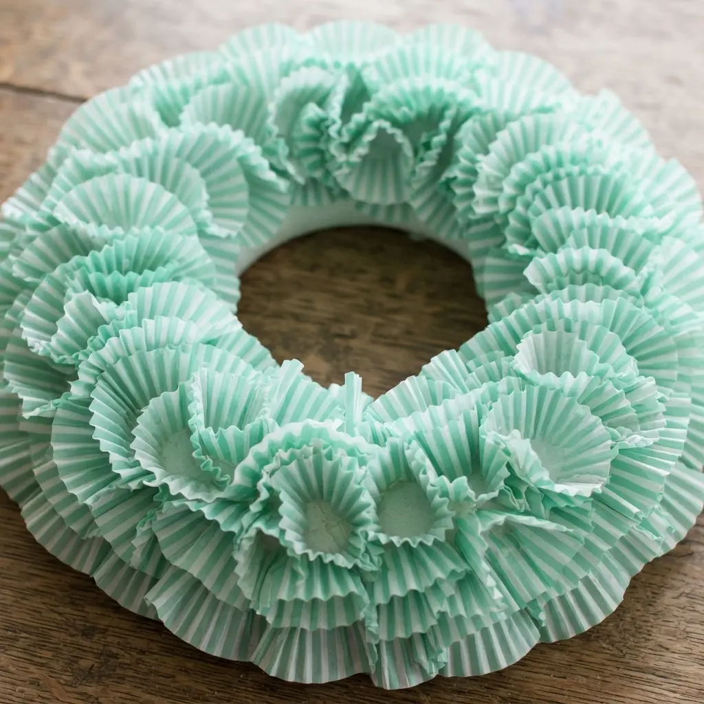 A clean, refreshing wreath using mint green and white striped cupcake liners gathered into uniform ruffles on a foam ring.