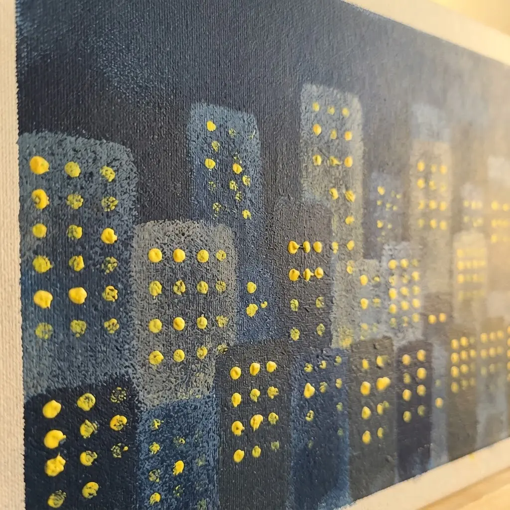 A dark blue canvas with a city skyline formed by sponge-stamped rectangular buildings and yellow window dots.