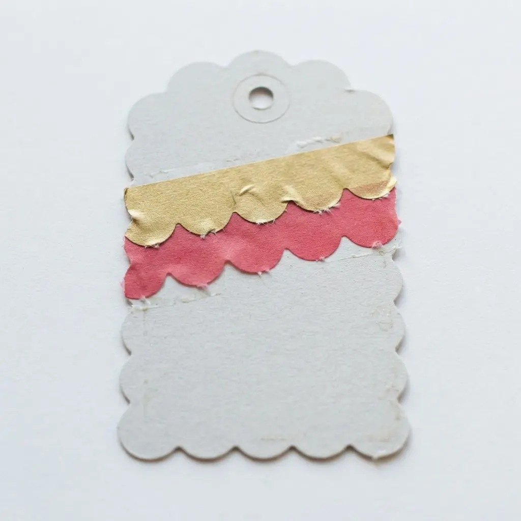 A gift tag with a decorative scalloped-edge banner shape made from a single piece of washi tape.