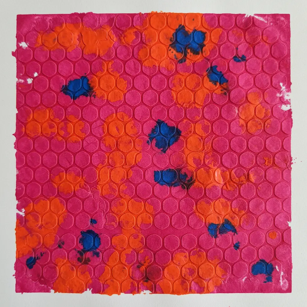 A piece of paper printed with a repeating bubble wrap pattern in bright magenta, orange, and blue.