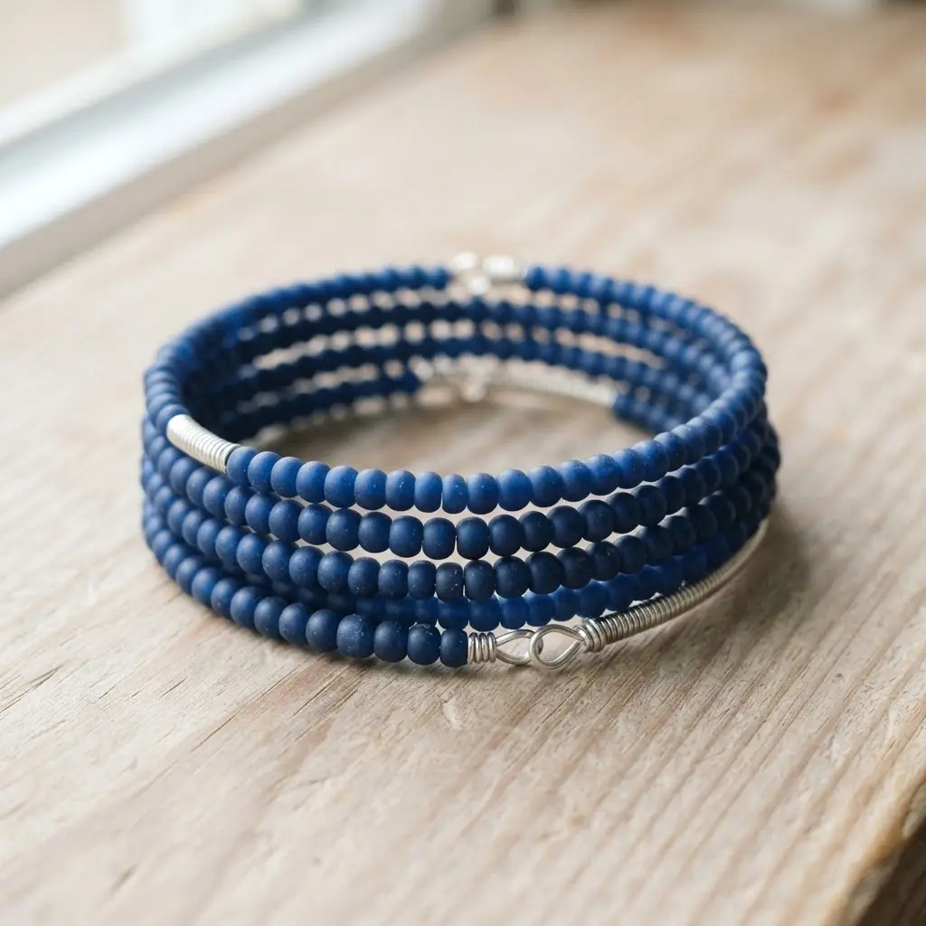 A coiled bracelet made from memory wire featuring a dense stack of round matte finish glass beads in a deep blue tone.