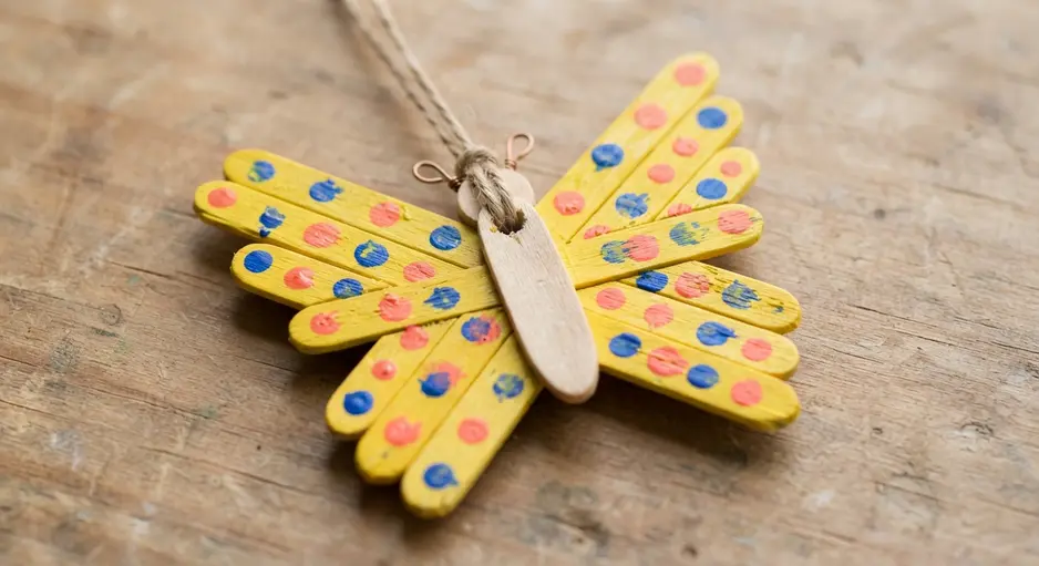 A butterfly-shaped pendant with yellow wings covered in multi-colored polka dots.