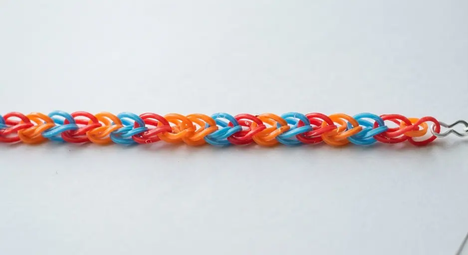 A classic rainbow loom bracelet in a straight line of alternating bright colors.