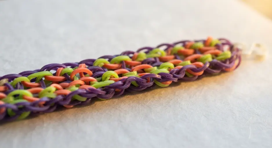 A bracelet showing a ladder-like pattern with parallel lines of different colored bands.
