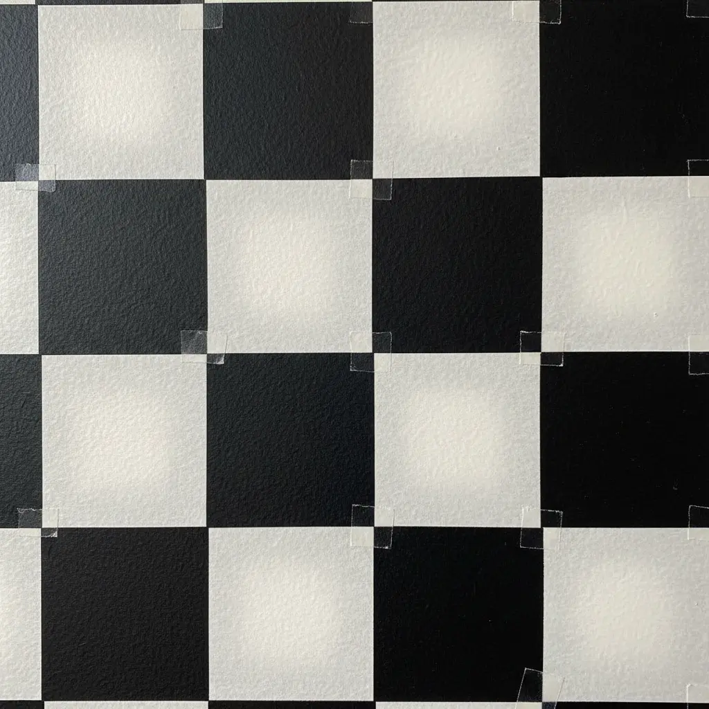 A checkerboard pattern created with black and white tape, giving a retro graphic look to the wall.