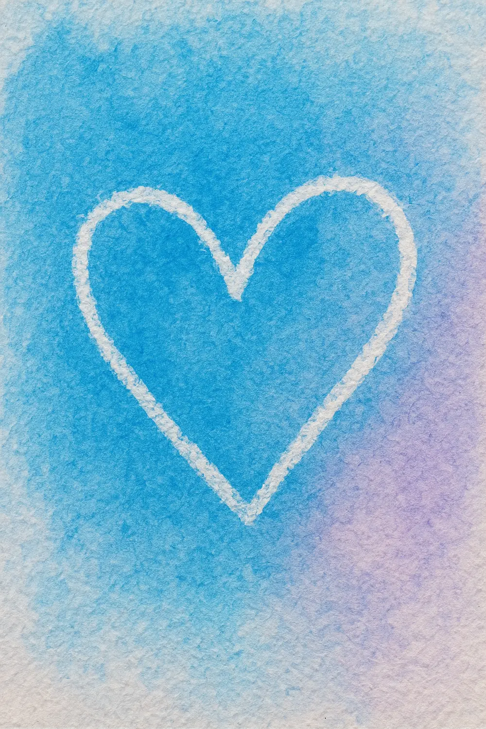 A white heart shape outlined in crayon stands out against a colorful watercolor background.