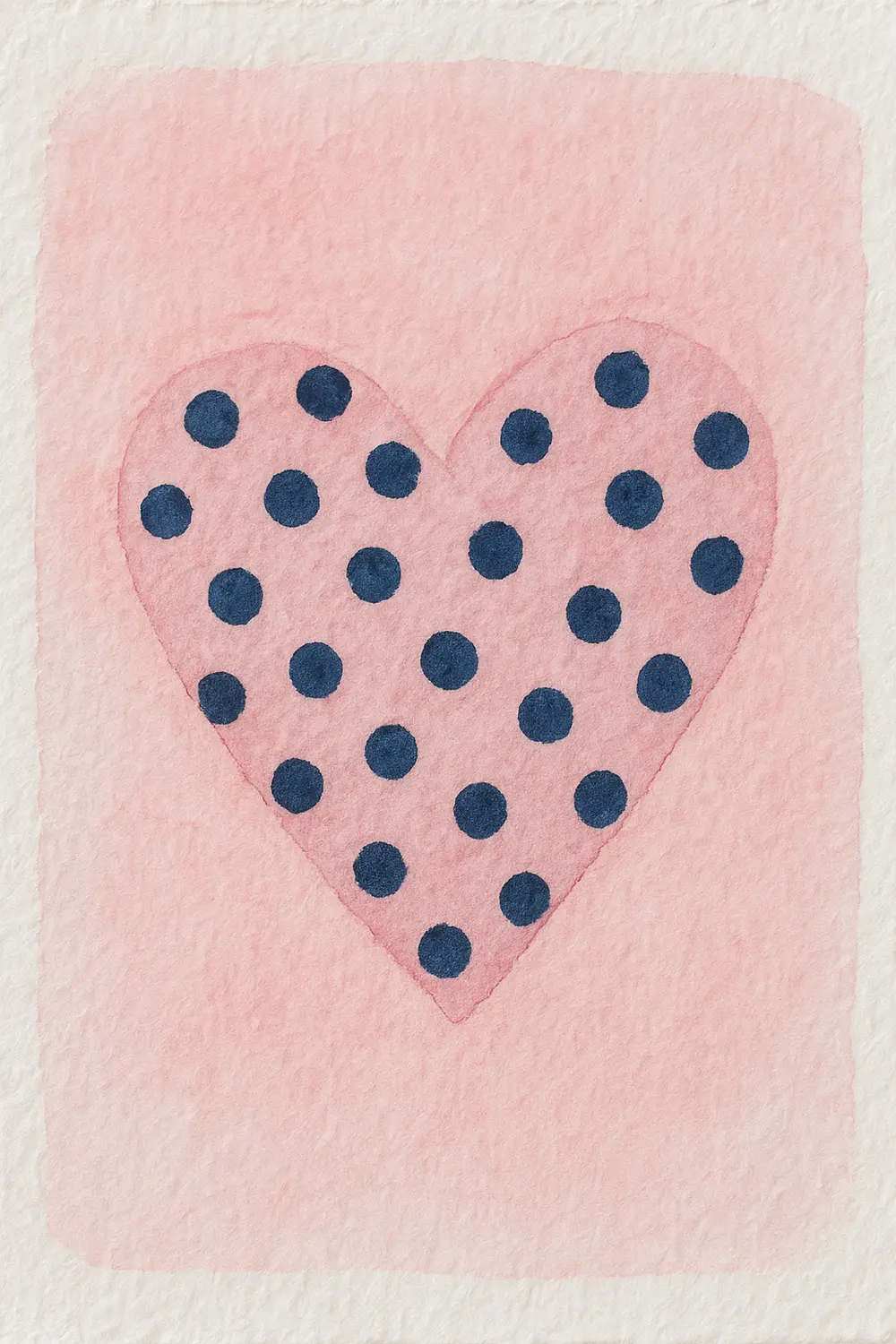 A light pink watercolor heart covered with dark purple polka dots.